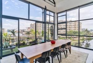 una grande camera con tavolo e sedie in legno di Stylish & New 4 Bedroom Point Waterfront Penthouse a Durban