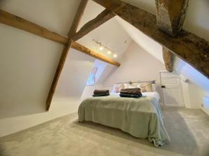 a bedroom with a bed in an attic at Beautiful 17th century coach house off high street in Marlborough