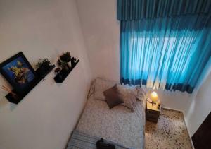 a small room with a couch and a blue curtain at Sea view 3-bedroom flat in Puerto de Mazarron in Puerto de Mazarrón