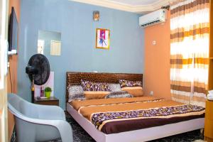1 dormitorio con 1 cama en una habitación con paredes azules en A' BASICS APARTMENTS & SUITES en Ibadán