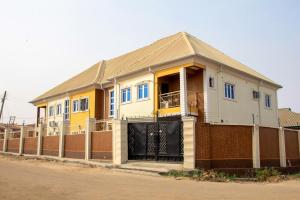 una casa gialla sul lato di una strada di A' BASICS APARTMENTS & SUITES a Ibadan