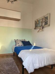 a bedroom with a bed with blue and white sheets at Casa Girassol in Santiago do Cacém