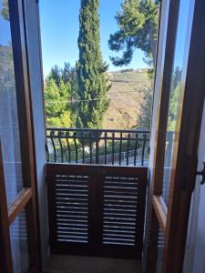 a door to a balcony with a view of a tree at La Casa di Serra in Serramonacesca
