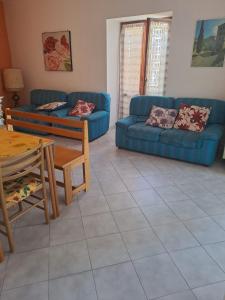 a living room with a blue couch and a table at La Casa di Serra in Serramonacesca