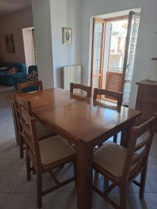 Serramonacesca的住宿－La Casa di Serra，客厅配有一张木制餐桌和椅子