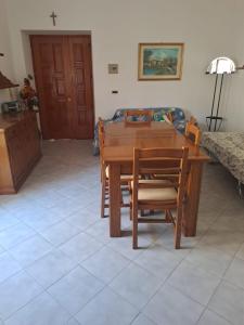 uma mesa de madeira e cadeiras numa sala de estar em La Casa di Serra em Serramonacesca