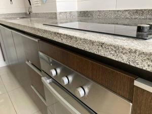 a kitchen with a granite counter top with silver drawers at Lindo duplex frente al Mar in Coquimbo