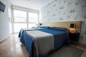 Un dormitorio con una cama y una pared con escritura. en Pensión Zumardi, en Deba