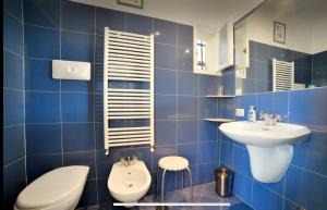 ナポリにあるLe terrazze di Chiaiaの青いタイル張りのバスルーム(洗面台、トイレ付)