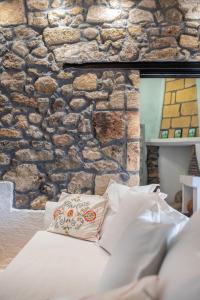 a stone wall with a bed with a pillow at Philoxenia traditional house in Pastida