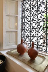 two vases sitting on a window sill in front of a window at Riad Noor Charana in Marrakesh