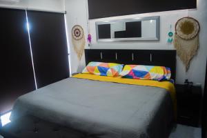 Un pat sau paturi într-o cameră la CASA PALOMA 2 EN SEGUNDA PLANTA CERCA DE AEROPUERTO Y CENTRO COMERCIAL