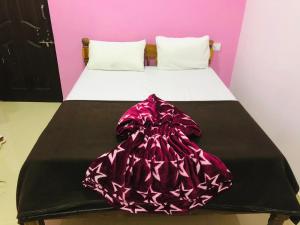 un letto con una coperta rosa e nera sopra di Pihu guest house a Calangute