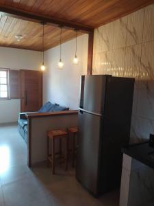 cocina con nevera, mesa y cama en Casa Almeida en Tiradentes