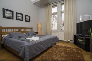 a bedroom with a bed and a flat screen tv at Apartment Dusni in Prague