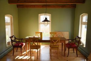 a dining room with a wooden table and chairs at Forsthaus Lelkendorf / Ferienwohnung in Lelkendorf
