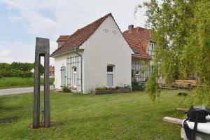 una casa blanca con un patio delante en Forsthaus Lelkendorf / Ferienwohnung en Lelkendorf