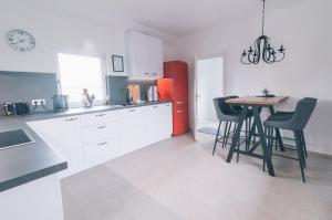 cocina con mesa, sillas y nevera roja en Ferienwohnung In den Wiesen, en Wesel