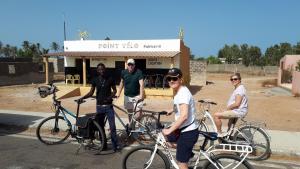 un grupo de personas con sus bicicletas delante de una tienda en Villa avec piscine entre plage et Siné Saloum, en Palmarin