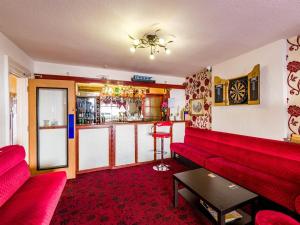 a living room with a red couch and a bar at Holmeleigh Hotel in Blackpool