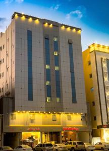 budynek z samochodami zaparkowanymi przed nim w obiekcie برج الشمال للشقق الفندقية Burj ALShamal w mieście Tabuk