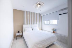 Un dormitorio blanco con una cama grande y una ventana en Luxury Penthouse at Davidka JRSLM, en Jerusalén