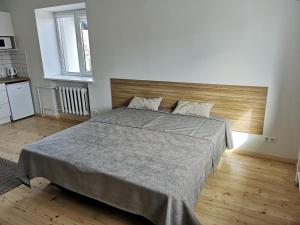 a bedroom with a large bed with a wooden headboard at COMFY Patogūs namai in Kaunas