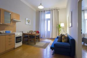 a kitchen and living room with a blue couch and a table at Apartment Dusni in Prague