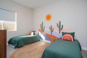 1 dormitorio con 2 camas y pared de cactus en Luxury Rental Signature PGA West Pool Spa Putting green, en La Quinta 41 fotos más