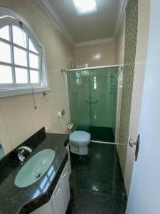 a bathroom with a sink and a shower and a toilet at Elite Flat in Pará de Minas