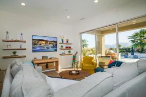 Una sala de estar con un sofá y un televisor. en Luxury Rental Signature PGA West Pool Spa Putting green, en La Quinta