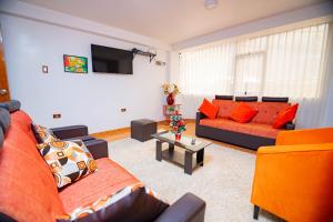 a living room with two couches and a tv at Departamento KIRI familiar ó empresarial cerca al Aeropuerto de Juliaca- Perú in Juliaca