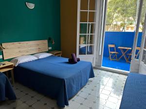 a bedroom with a blue bed and a large window at Hostel Friends Barcelona in Barcelona