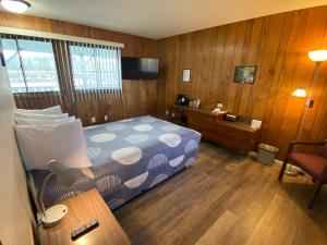 a bedroom with a bed and a desk with a lamp at Waterway Inn in Indian River