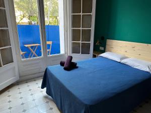 Un dormitorio con una cama azul con un animal de peluche púrpura. en Hostel Friends Barcelona, en Barcelona