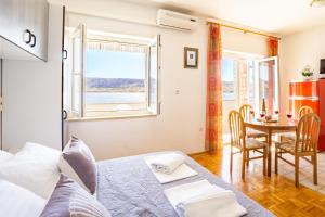 een slaapkamer met een bed, een tafel en een raam bij Galinec with mountain and seaview in Metajna