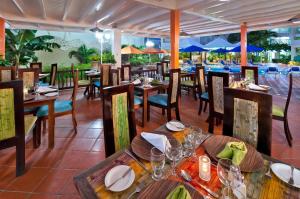 um restaurante com mesas de madeira e cadeiras e mesas e chairsktop em Blue Horizon Hotel em Bridgetown