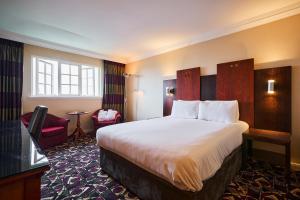 um quarto de hotel com uma cama grande e uma janela em Stirling Highland Hotel- Part of the Cairn Collection em Stirling