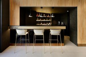 a bar with three stools in front of a counter at HCC Taber in Barcelona