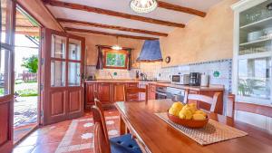 a kitchen with a wooden table with a bowl of fruit at Casa Rural Cortijo El Potro in Órgiva