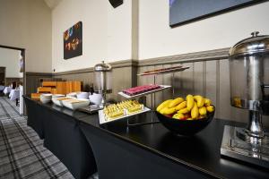 Stirling Highland Hotel- Part of the Cairn Collection في ستيرلينغ: طابور بوفيه مع وعاء من الموز والأطعمة الأخرى