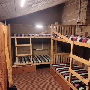 a room with three bunk beds in a room at Mud Hostel Shangarh in Shangarh
