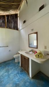 a bathroom with a sink and a mirror and a toilet at Casa Yuluka en la playa, Palomino in Palomino