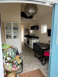 een woonkamer met een tafel en een keuken bij Renovated & private Tinyhouse Den Haag short stay appartment in Den Haag
