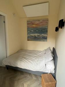 een slaapkamer met een bed met een schilderij aan de muur bij Renovated & private Tinyhouse Den Haag short stay appartment in Den Haag