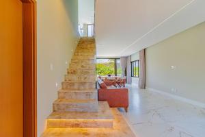 - un escalier dans une maison avec un salon dans l'établissement SA07 Maravilhosa Casa 5 Suítes - Reserva de Sauípe, à Costa do Sauipe