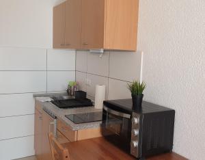 a kitchen with a black microwave and a counter top at Workers-Sleep-Station in Cologne