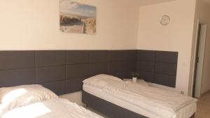 1 dormitorio con 2 camas y reloj en la pared en Workers-Sleep-Station, en Colonia