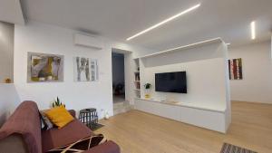 uma sala de estar com um sofá e uma televisão na parede em Over the Castle Apartment em Trento