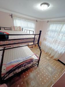 two bunk beds in a room with windows at we are one apartment in Arusha